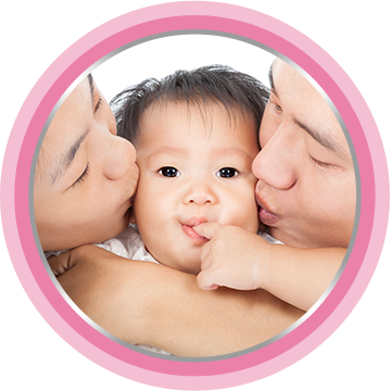 Parents laying on bed with baby in a diaper. To avoid skin irritation, it's best to use baby bottom cream.